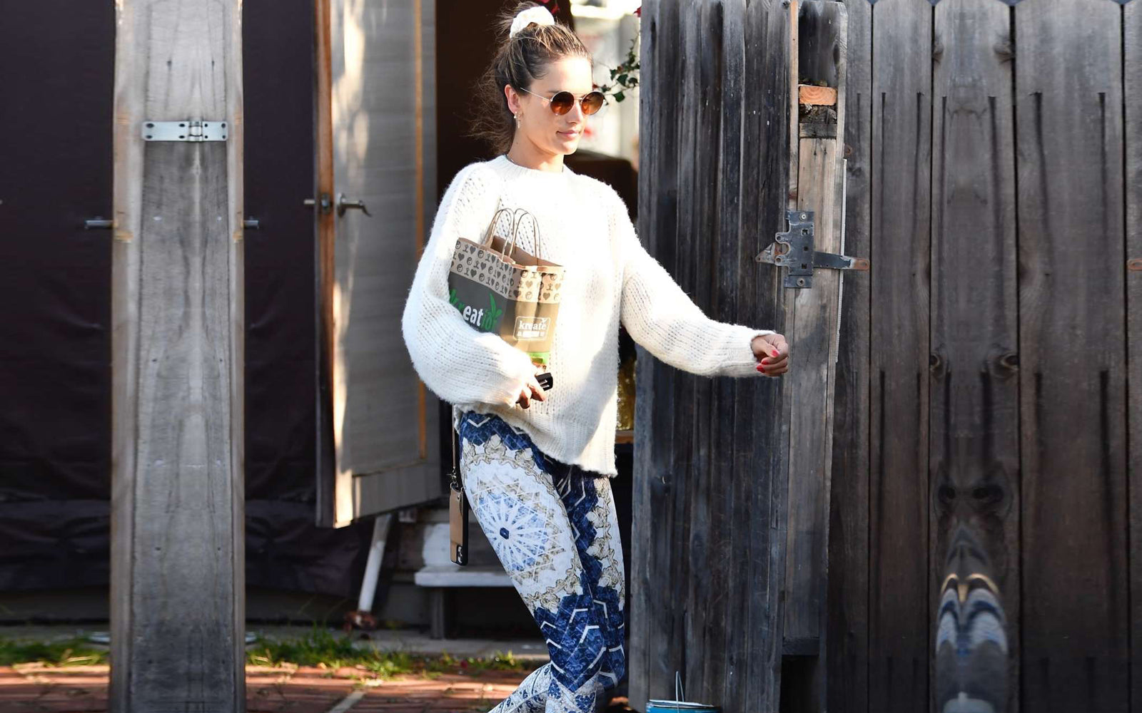 Alessandra Ambrosio wears a white top and aqua blue leggings as